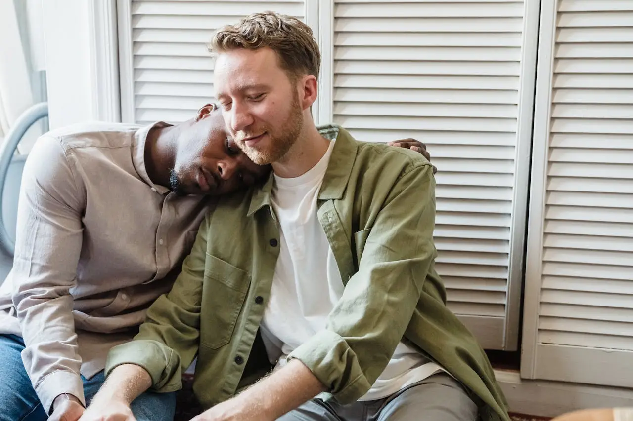 A heartwarming scene of a couple sitting together, embracing a tender moment indoors.