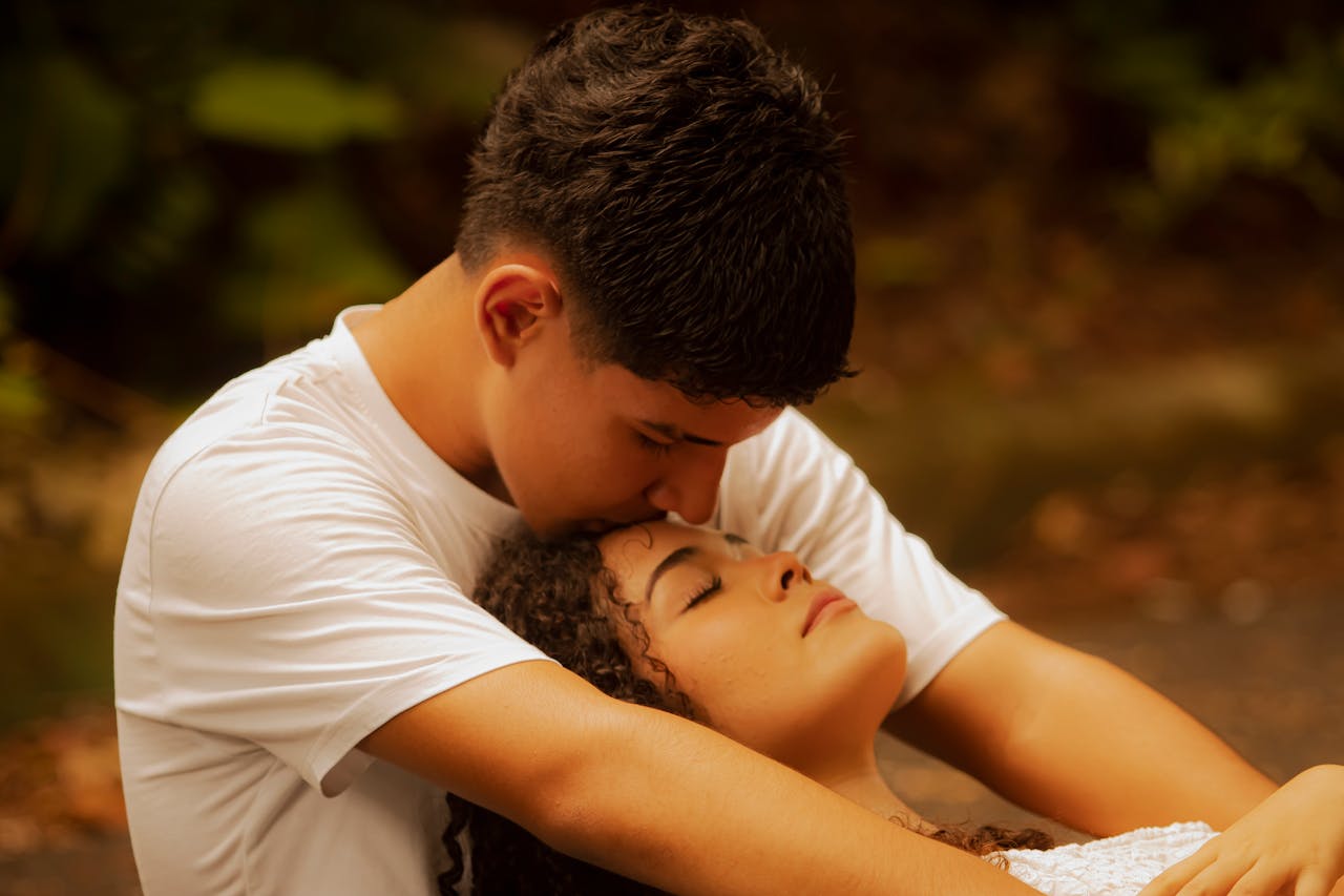 Romantic young couple sharing an affectionate moment outdoors, creating a warm and intimate atmosphere.
