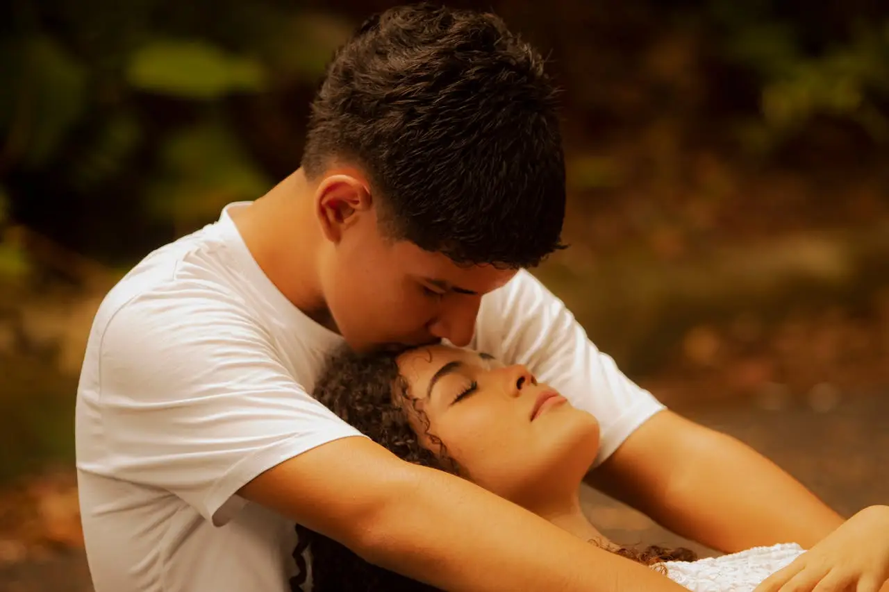 Romantic young couple sharing an affectionate moment outdoors, creating a warm and intimate atmosphere.
