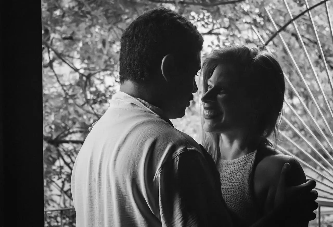 Black and white photo of a couple embracing, creating an intimate romantic moment.
