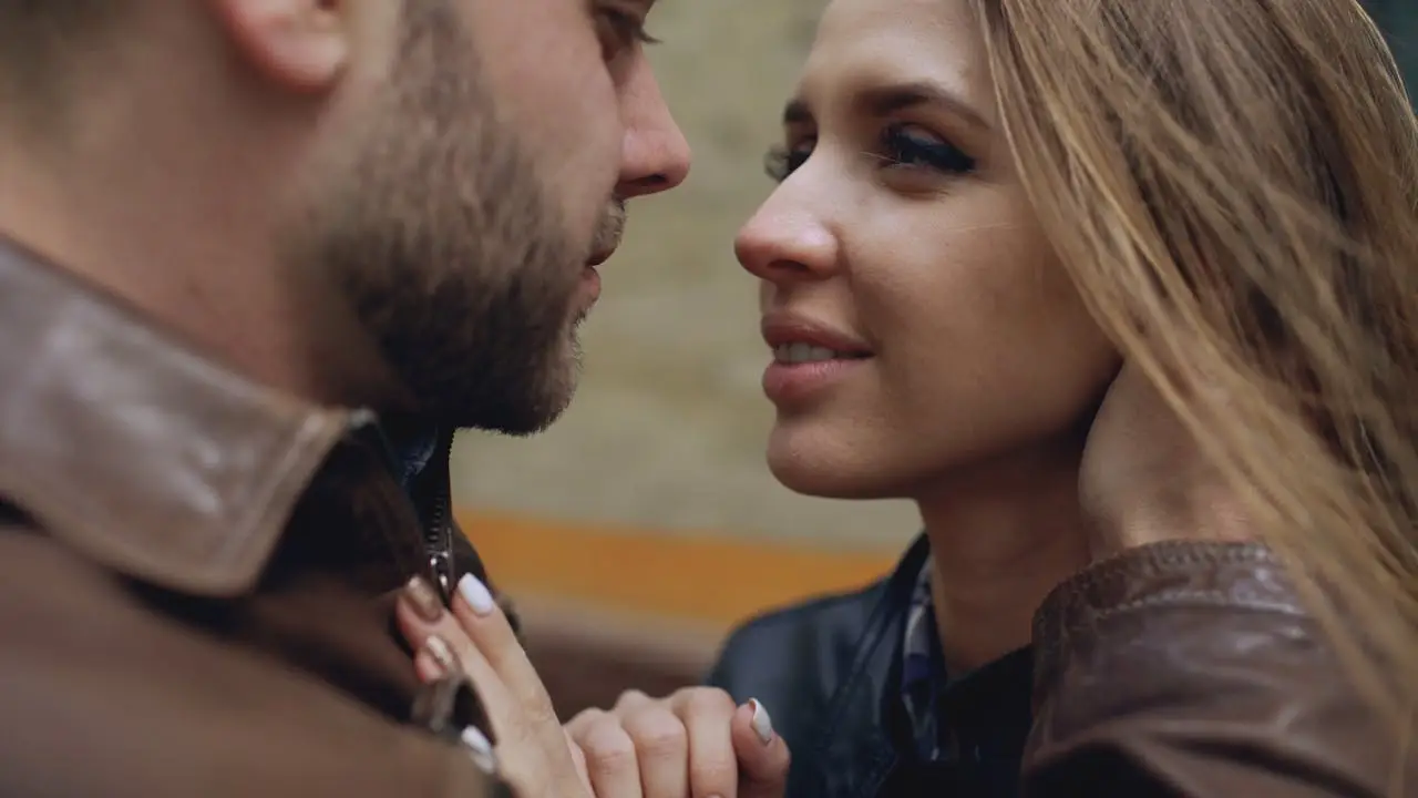 An intimate close-up of a couple embracing lovingly outdoors.