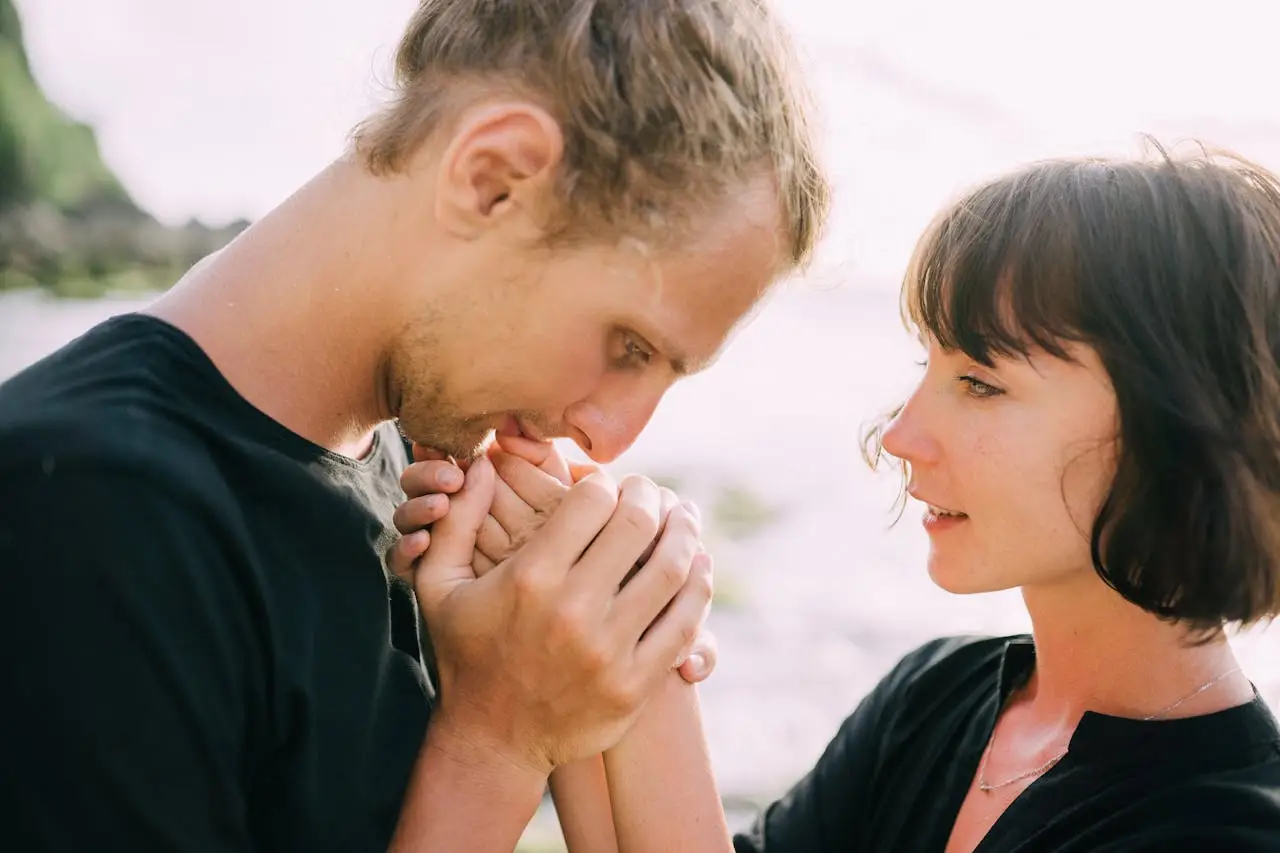 Romantic couple sharing a tender moment near the beach, expressing love and affection in a natural setting.